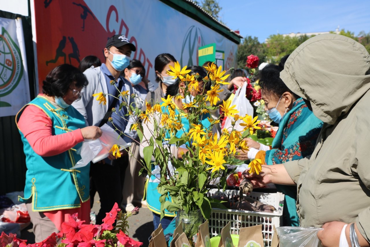 Волонтеры цветы. Кызыл праздник. Фестиваль урожая в Японии когда появился. Девушка с корзиной на шее раздает цветы на мероприятии.